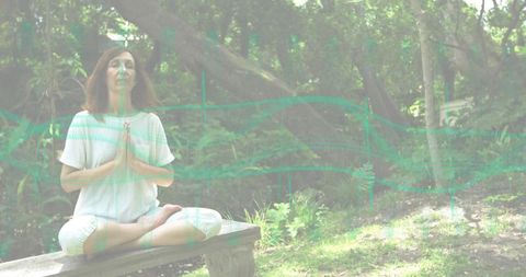 Mature woman meditating on bench in forest clearing wearing white, barefoot, serene