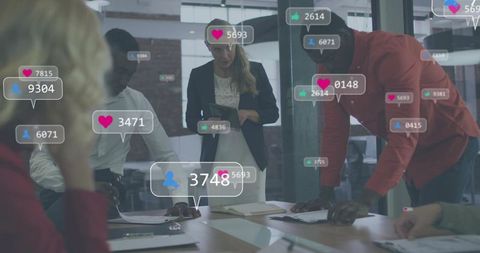 Collaborative team analyzing social media metrics and engagement analytics around meeting table