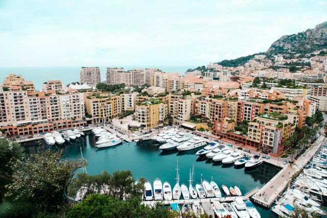 A stunning view of a marina filled with luxury yachts surrounded by charming waterfront residential buildings. Ideal for promoting coastal living, real estate, travel, tourism, and lifestyle services. Great for use in travel blogs, brochures, and real estate websites.