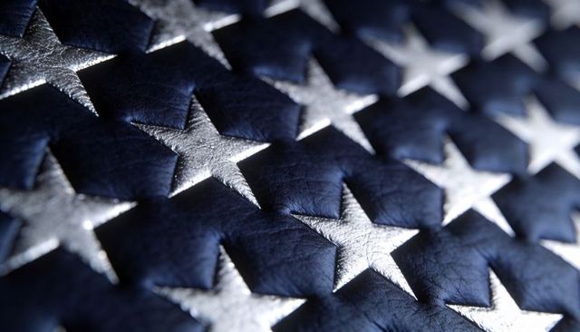 Displaying Metallic Silver Stars on Quilted Navy Leather Texture, Closeup Decorative Pattern