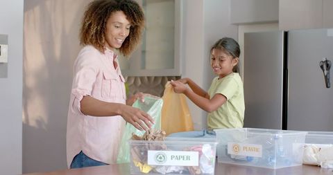 Mother and Daughter Recycling Together in Kitchen for Sustainable Living