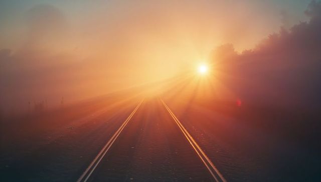 Sunrise Illuminating Foggy Roadway Creating Mystical Atmosphere