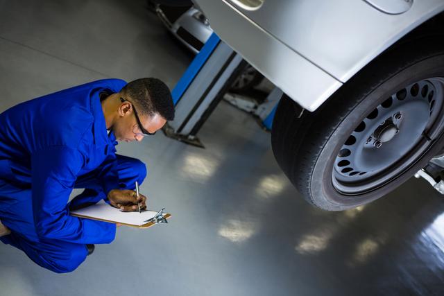 Attentive Mechanic Preparing Checklist in Repair Garage - Download Free Stock Photos Pikwizard.com