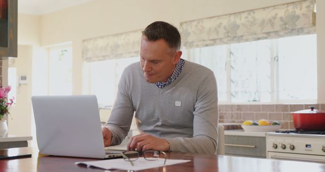 Man Working on Laptop in Bright Modern Kitchen Interior - Download Free Stock Images Pikwizard.com