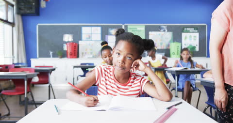 Student Daydreaming in Classroom While Writing