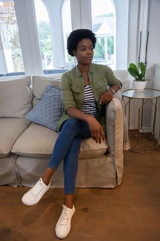 Woman Relaxing on Cozy Living Room Couch in Casual Outfit