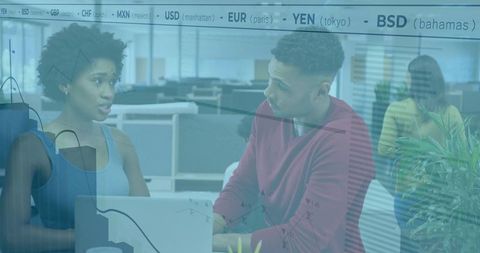 Colleagues Collaborating Over Laptop With Financial Data Overlay in Modern Office Space
