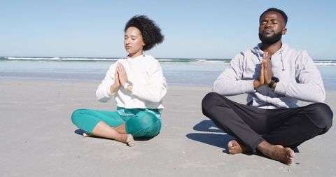 Young Couple Meditating on Calm Sandy Beach Practicing Yoga and Mindfulness Outdoors