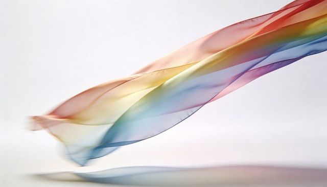 Flowing pastel chiffon ribbon drifting diagonally with soft shadow