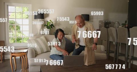 Senior couple pointing at laptop and sharing takeout while navigating digital numbers