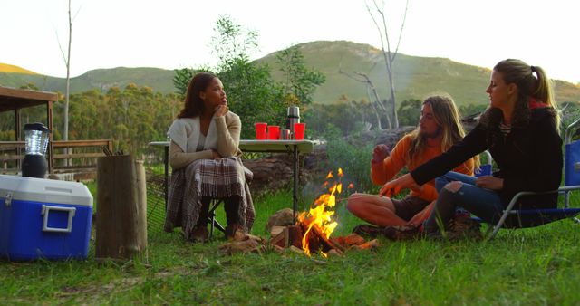 Friends Enjoying Campfire in Scenic Outdoor Setting - Download Free Stock Images Pikwizard.com