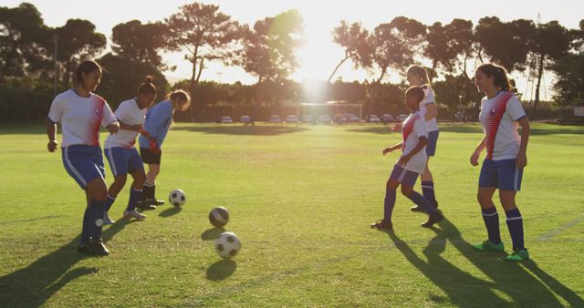 Team of diverse female football players playing football on sunny sports field - Download Free Stock Photos Pikwizard.com