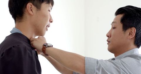 Proud Father Congratulating Graduating Son at Home