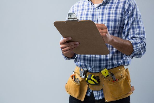 Male architect holding clipboard and wearing tool belt with various tools. Ideal for use in construction, engineering, and project management contexts. Suitable for illustrating concepts of planning, inspection, and professional work in the building industry.