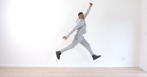 Energetic man leaping in minimalist space