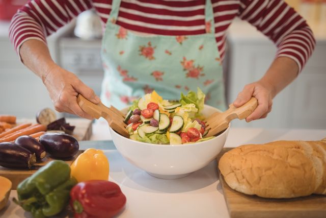 Senior Woman Preparing Fresh Vegetable Salad in Kitchen - Download Free Stock Photos Pikwizard.com