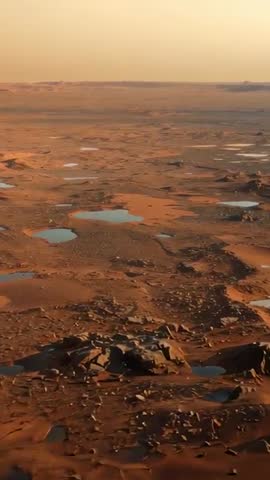 Vertical drone pass revealing red desert plains with scattered basins and mapping pools