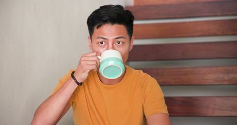 Man Enjoying Coffee at Stylish Minimalist Cafe