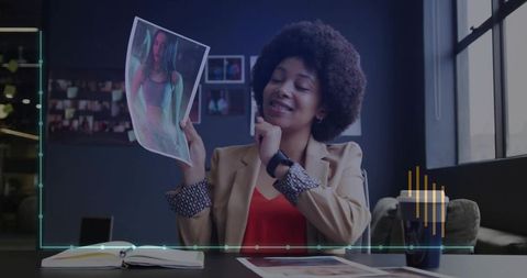 Smiling Professional Reviewing Photographs in Modern Office