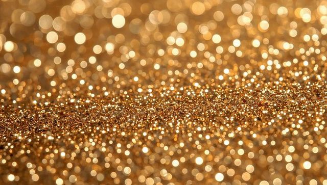 Sparkling gold glitter macro background with metallic flakes, bokeh and shimmer