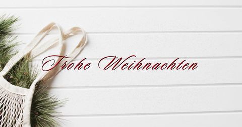 Frohe weihnachten text on white wooden background with pine branches