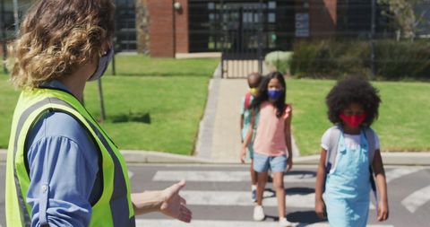 Female Crossing Guard Assists Kids in Masks at Pedestrian Crosswalk - Download Free Stock Images Pikwizard.com