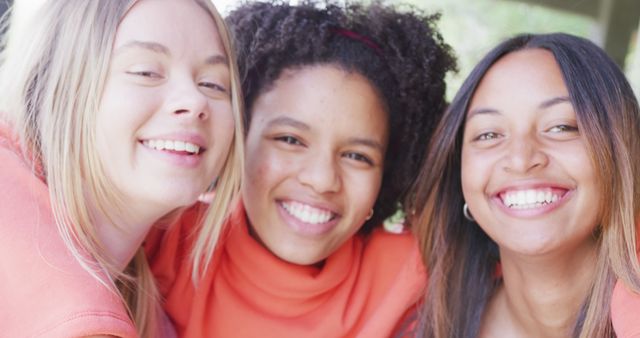 Portrait of happy diverse teenager girls looking at camera and smiling. Spending quality time, lifestyle, friendship and adolescence concept.