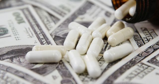 White capsules are spilled from a dark bottle onto US dollar bills, suggesting the high cost of healthcare or medication. The scene underscores the intersection of pharmaceuticals and economics, highlighting issues of affordability and access to medicine.