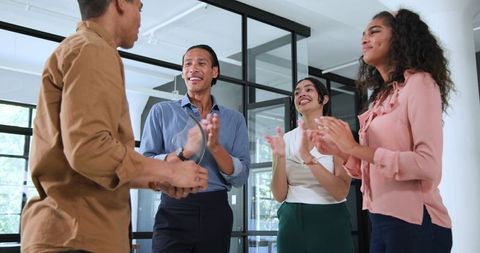 Ecstatic Team Celebrating Successful Colleague Achievement in Modern Office