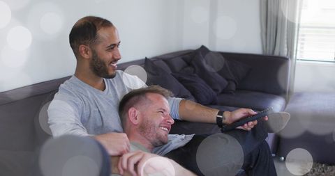 Happy Diverse Couple Relaxing on Sofa Watching TV Together