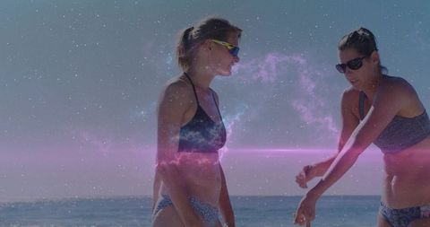Pointing beach summer friends wearing bikinis and sunglasses with cosmic nebula overlay