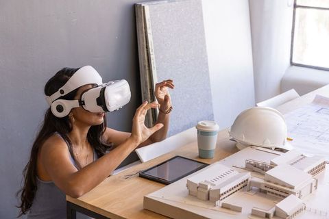Architectural designer using vr headset with building model