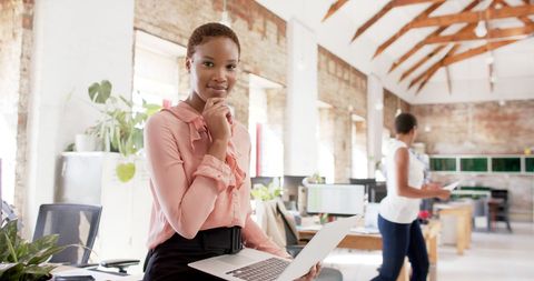Confident Businesswoman Holding Laptop in Modern Office - Download Free Stock Images Pikwizard.com