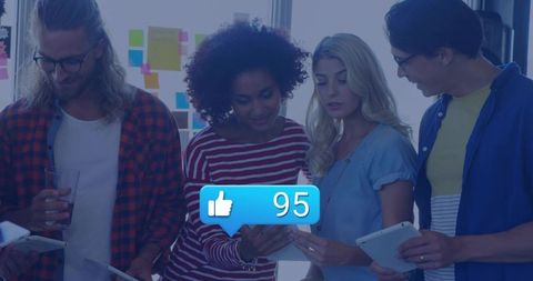 Young professionals collaborating on tablets with social likes overlay in modern workspace