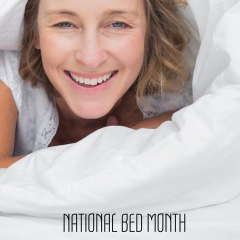 Woman smiling in cozy white bedding celebrating national bed month
