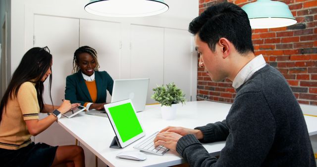 Diverse Team Collaborating in Modern Office Space with Laptops and Tablets - Download Free Stock Images Pikwizard.com