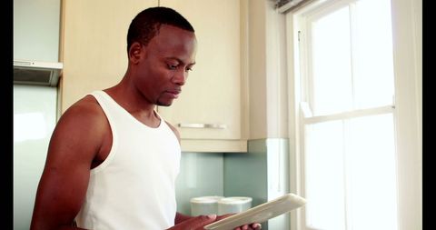 Man using tablet in bright kitchen setting for modern living