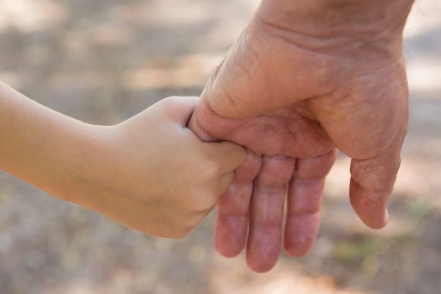 Grandfather holding his granddaughter hand in the forest - Download Free Stock Photos Pikwizard.com