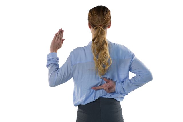 Businesswoman in professional attire crossing fingers behind her back, symbolizing dishonesty or broken promises. Useful for illustrating concepts of deception, ethics in business, or untrustworthy behavior in corporate settings.