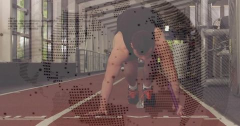 Sprinter preparing in starting blocks on indoor track with dotted world map overlay