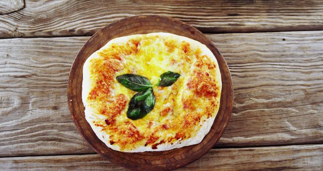 Margherita pizza with melted cheese and fresh basil leaves on a rustic wooden table. Ideal for food blogs, restaurant menus, or culinary websites. Perfect for promoting Italian cuisine, highlighting homemade pizza, or illustrating traditional meals.