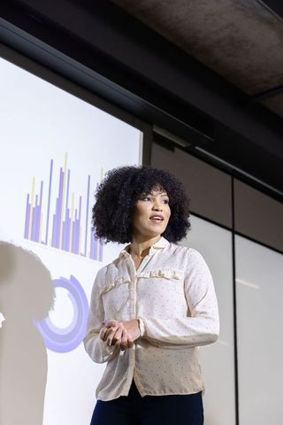 African American Businesswoman Presenting Data in Meeting Room