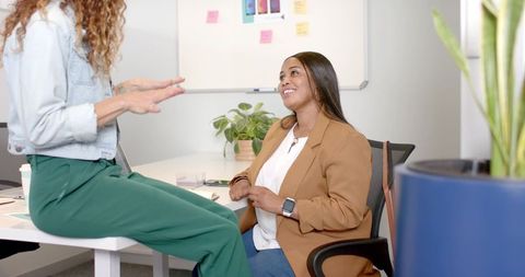 Diverse female coworkers engaged in creative idea sharing