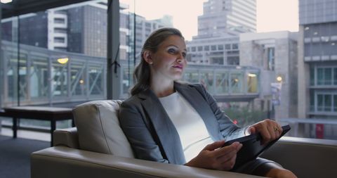Businesswoman Using Tablet in Modern Office Lounge During Evening
