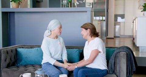 Supportive friends talking at home for cancer awareness