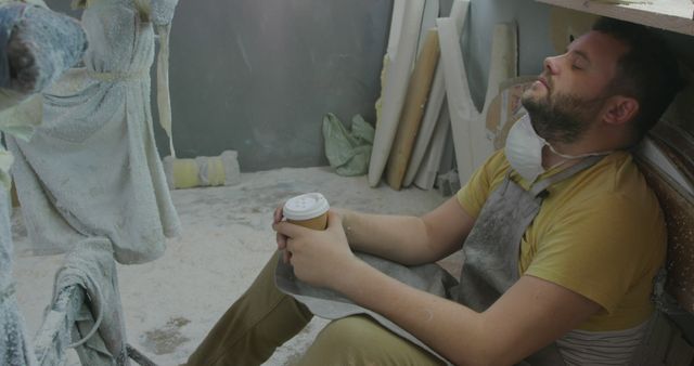 Tired Worker Resting in Dusty Workshop with Coffee - Download Free Stock Images Pikwizard.com