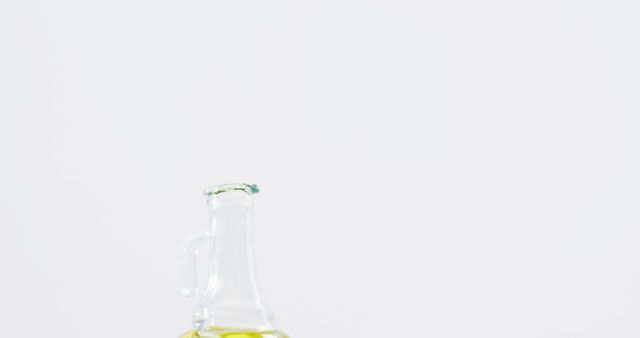 Glass bottle filled with olive oil on white background. Ideal for cooking blogs, healthy eating articles, kitchen ingredient photography, and organic food marketing materials.