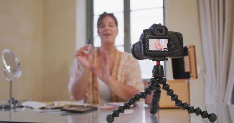 Beauty vlogger recording makeup tutorial at home