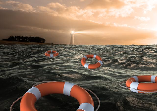 Lifebuoys floating on a stormy sea with a lighthouse shining in the background during sunset. This image can be used to depict themes of safety, rescue, maritime emergencies, and survival. Ideal for use in articles, advertisements, and educational materials related to ocean safety, emergency preparedness, and maritime navigation.