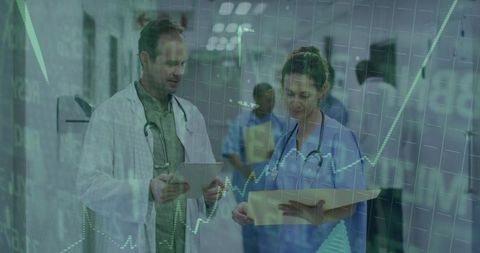 Doctors Discussing Clinical Data in Hospital Corridor